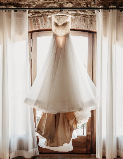 une robe de mariée sur un cintre accrochée au mur