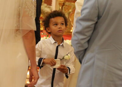 un enfant tenant les alliances des mariés dans ses mains