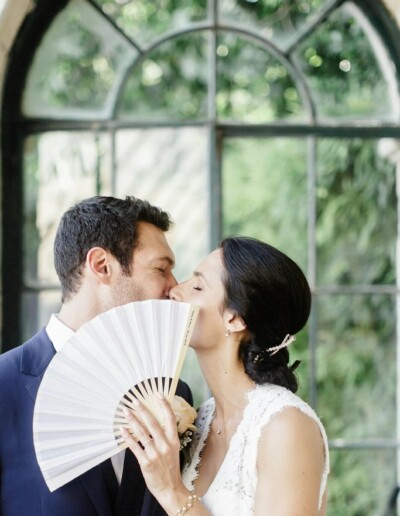 wedding planner Montpellier et Occitanie : les mariés s'embrassent derrière un éventail