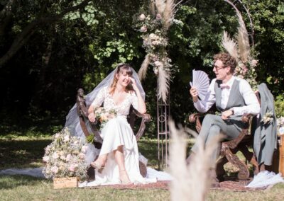 mariage à Nîmes, les mariés en plein air assis sur de beaux sièges en bois pendant la cérémonie laïque, le marié tient un éventail