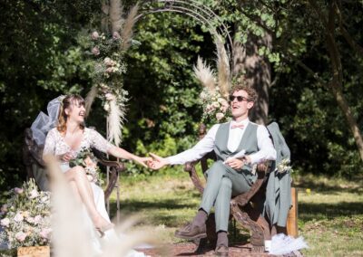 mariage à Nîmes, les mariés en plein air assis sur de beaux sièges en bois pendant la cérémonie laïque