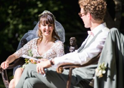 mariage à Nîmes, les mariés en plein air assis sur de beaux sièges en bois se regardent